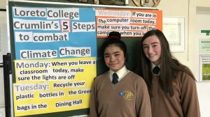 Keiffer Cortez and Sophie O'Connor in front of 5 Easy steps to combat climate change display in our school reception area.